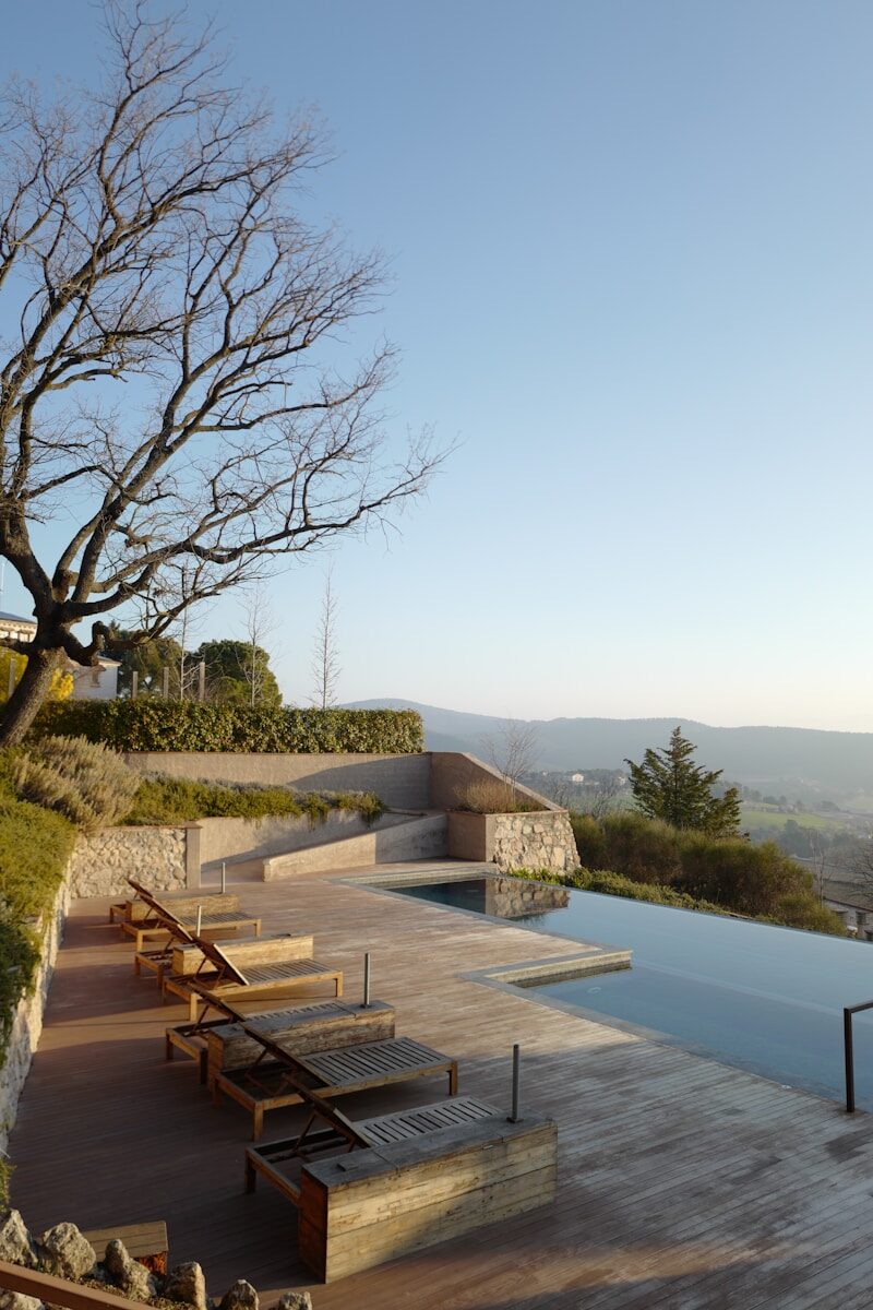 a wooden deck next to a swimming pool