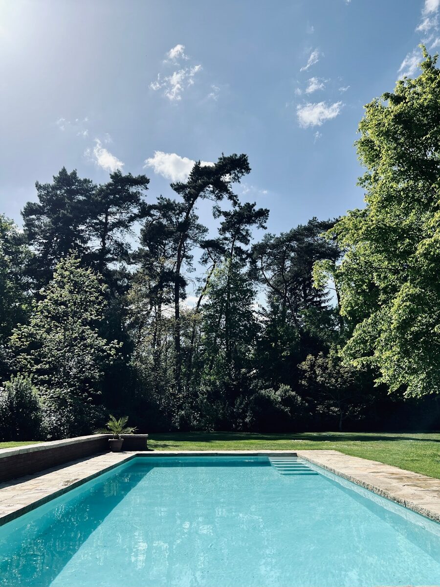a swimming pool surrounded by trees and grass